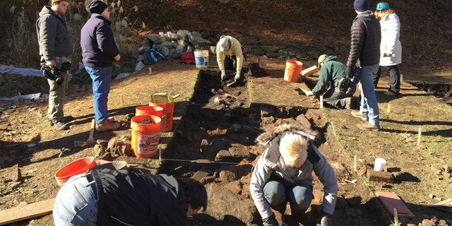This Nov. 19, 2014 photo made available by Bill Richardson, shows the descendants of the Hatfield and McCoy families clearing the homesite of Randall McCoy in Pike County, KY.