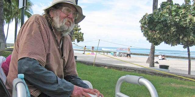 September 8, 2014: Jim Trevarthen, 62, watches the surfers near Waikiki Beach in Honolulu. Trevarthen is one of many homeless people who are unhappy with the city's proposals to ban sitting and lying down on sidewalks in the tourist mecca. (AP Photo/Cathy Bussewitz)