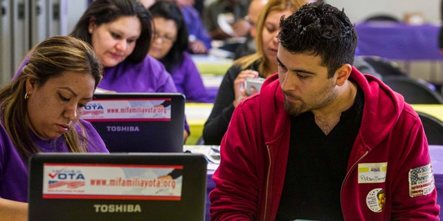 SEIU-UHW worker Kathy Santana, left , assists Ruben Torres, 27, during a health care enrollment event at SEIU-UHW office, Monday, March 31, 2014, in Commerce, Calif. Monday is the deadline to sign up for private health insurance in the new online markets created by President Barack Obama's health care law. (AP Photo/Ringo H.W. Chiu)