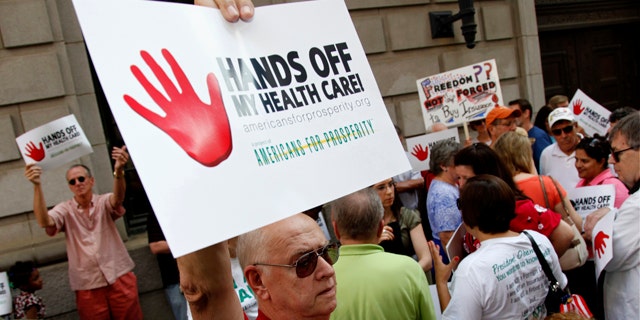 June 8: Mike Griffith, of Canton, Ga., holds a sign during a protest against President Barack Obama's health care reform plan outside the 11th Circuit Court of Appeals in Atlanta. A three-judge panel of the 11th Circuit Court of Appeals was hearing arguments on whether to reverse a Florida judge's ruling that struck down the law.