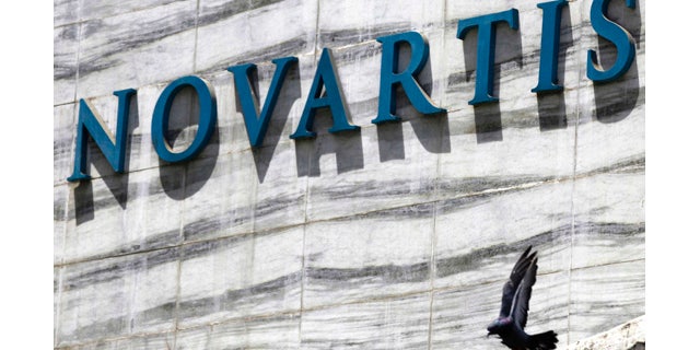 FILE - In this April 1, 2013 file photo, a dove flies near the logo of Novartis India Limited at their head office in Mumbai, India. A new study released Saturday, Aug. 30, 2014, shows an experimental Novartis drug, which does not have a name, lowered the chances of death or hospitalization by about 20 percent. (AP Photo/Rafiq Maqbool, File)