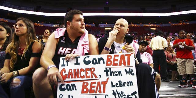 Two fans wait for the start of the Miami Heat's Red, White, and Pink basketball scrimmage Wednesday, Oct. 1, 2014, in Miami. (AP Photo/J Pat Carter)