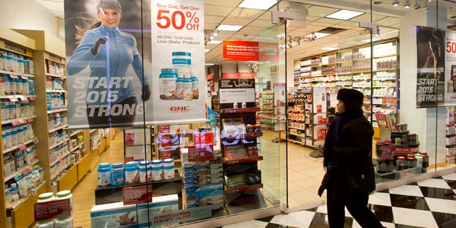 Feb. 3, 2015: A woman walks past a GNC store in New York. (AP Photo/Mark Lennihan)