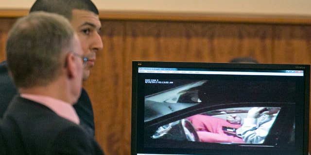 Aaron Hernandez, rear, and his attorney Charles Rankin watch surveillance video of Hernandez handling cell phones during his murder trial at the Bristol County Superior Court in Fall River, Mass. on Tuesday, Feb. 17, 2015. Hernandez is accused in the June 17, 2013, killing of Odin Lloyd, who was dating his fiancée's sister. (AP Photo/Dominick Reuter, Pool)