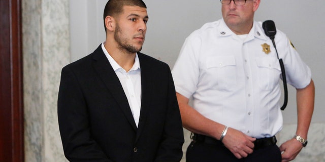 Former New England Patriots NFL football tight end Aaron Hernandez, left, appears at Attleboro District Court on Wednesday, July 24, 2013, in Attleboro, Mass. Hernandez has pleaded not guilty to murder in the death of Odin Lloyd. Hernandez was in court for what was supposed to be a probable cause hearing, but prosecutors said the grand jury is still considering the evidence against him. A judge rescheduled the probable cause hearing for Aug. 22, after considering defense objections to a delay. (AP Photo/Bizuayehu Tesfaye)