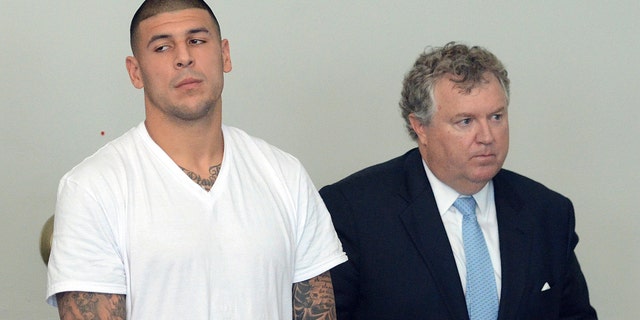 Former New England Patriots tight end Aaron Hernandez, left, stands with his attorney Michael Fee, right, during arraignment in Attleboro District Court Wednesday, June 26, in Attleboro, Mass. Hernandez was charged with murdering Odin Lloyd, a 27-year-old semi-pro football player for the Boston Bandits, whose body was found June 17 in an industrial park in North Attleborough, Mass. (AP Photo/The Sun Chronicle, Mike George, Pool)