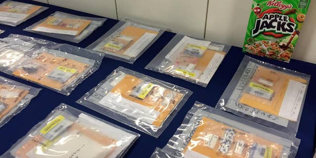 Packages of heroin fill a table during a news conference at the Brooklyn District Attorney’s Office in New York, Thursday, Sept. 17, 2015. A family-run heroin ring brought in more than $1.5 million in 2014 by using cereal boxes to conceal the drugs, which were sold to distributors including a court employee and a drug counselor, a district attorney said Thursday in announcing the arrests of two dozen people. (AP Photo/Michael Balsamo)
