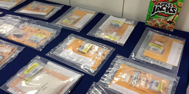 Packages of heroin fill a table during a news conference at the Brooklyn District Attorney’s Office in New York, Thursday, Sept. 17, 2015. A family-run heroin ring brought in more than $1.5 million in 2014 by using cereal boxes to conceal the drugs, which were sold to distributors including a court employee and a drug counselor, a district attorney said Thursday in announcing the arrests of two dozen people. (AP Photo/Michael Balsamo)