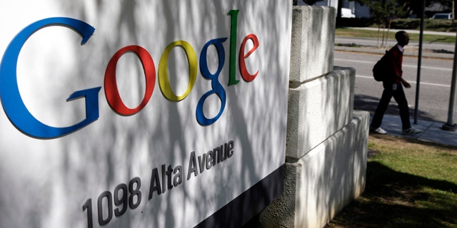 FILE - In this June 5, 2014 file photo, a man walks past a Google sign at the company's headquarters in Mountain View, Calif. (AP Photo/Marcio Jose Sanchez, File)