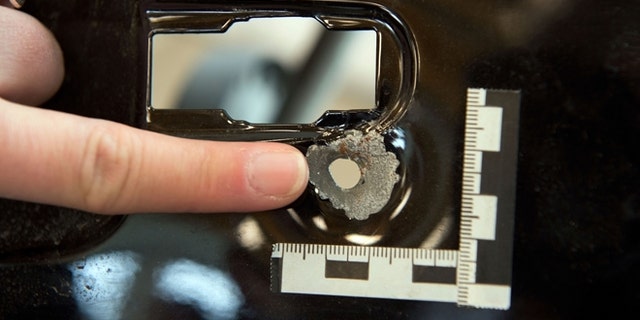 Nov. 20: An employee of the Federal Bureau of Criminal Investigation points at a bullet hole found in a car at the BKA headquarters in Wiesbaden, central Germany.