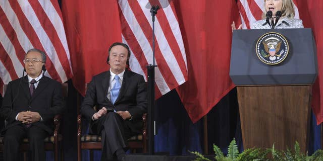 Secretary of State Hillary Rodham Clinton speaks as Chinese Vice Premier Wang Qishan, center, and Chinese State Counselor Dai Bingguo, left, listen during the opening session of the joint meeting of the U.S.-China Strategic and Economic Dialogue (S&ED), Monday, May 9, 2011, at the Interior Department in Washington. (AP Photo/Susan Walsh)