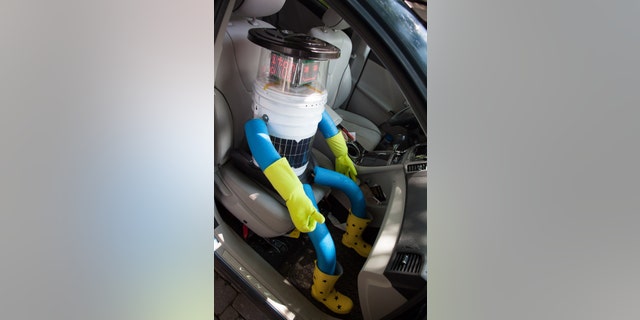 This undated photo made available by Ryerson University in Toronto on Thursday, Aug. 14, 2014 shows hitchBOT in a car. The talking robot that's been hitchhiking rides from strangers to travel from Canada's east to west coast is nearing the end of its journey. Its final destination is Victoria, British Columbia, Canada which its creators expect it to reach by Aug. 17, 2014. (AP Photo/Ryerson University)