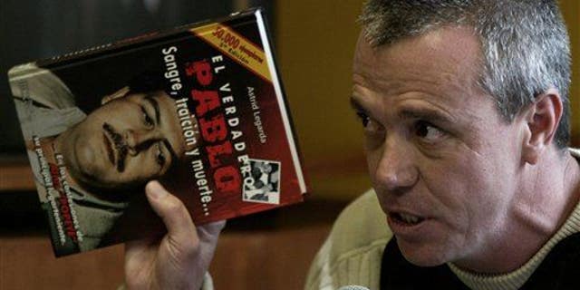 In this June 27, 2006, photo, Jhon Jairo Velasquez, a former hit man for Pablo Escobar, testifies while holding a book titled "The True Pablo: Blood, Treason, and Death."