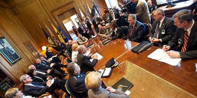 Reporters listen to Attorney General Eric Holder before his meeting with police officials, March 22