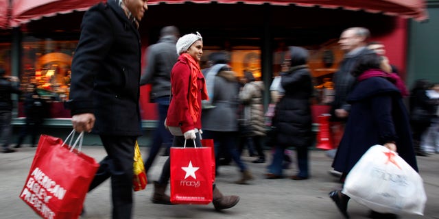 Dec. 18: Shopping bags in hand, consumers walk down 34th Street in New York. Retailers saw a spike in holiday shopping the last weekend before Christmas as retail revenue went up 5.5 percent.