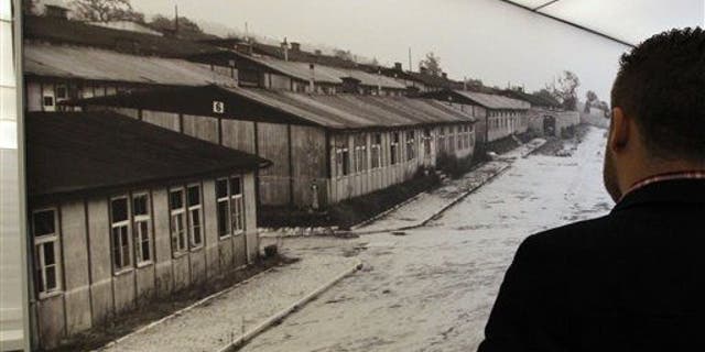 A visitor looks at a poster of the former Nazi concentration camp of Mauthausen during a press preview in a new memorial room in the former camp in Mauthausen, Austria.