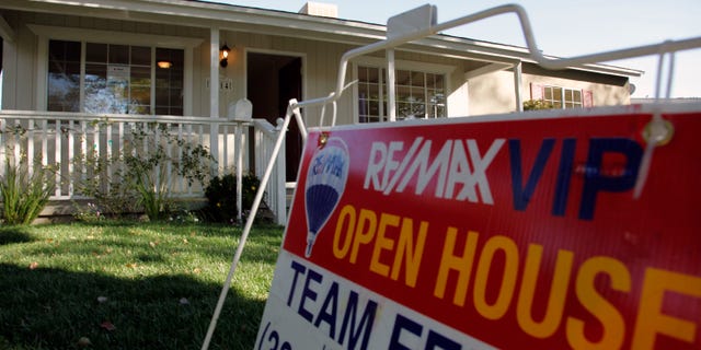 In this Nov. 4, photo, an open house sign is seen on the front lawn of a home for sale in Los Angeles. Home prices are dropping in the nation's largest cities and are expected to fall through next year, with the worst declines coming in areas with high numbers of foreclosures.
