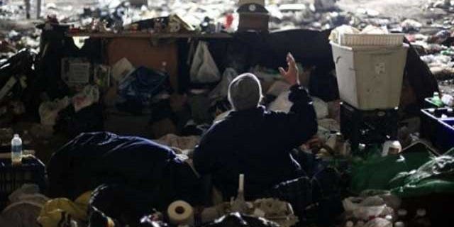 A homeless veteran who declined to be identified speaks with an outreach worker, not pictured, under an overpass during a winter storm in Philadelphia, Wednesday, Jan. 26, 2011. A code blue alert for severe weather has been issued by the city to encourage and sometimes compel the homeless to seek shelter.