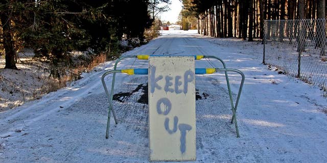 FILE - In this Nov. 26, 2012 file photo, a keep out sign stands at the property of Byron David Smith, in Little Falls, Minn. The Little Falls man who claimed he was defending his home from teens who had been terrorizing him for months goes on trial Monday, April 14, 2014, for their murders. (AP Photo/The Star Tribune, Elizabeth Flores) MANDATORY CREDIT; ST. PAUL PIONEER PRESS OUT; MAGS OUT; TWIN CITIES TV OUT