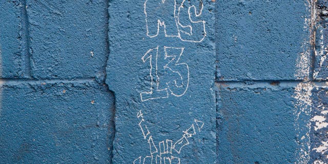 In this 2014 file photo, MS-13 gang graffiti is seen next to the door of the Jose Ramon Montoya school in Tegucigalpa, Honduras.