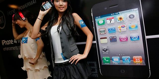 July 15, 2010: Models hold the iPhone 4 during a promotional event in Hong Kong.