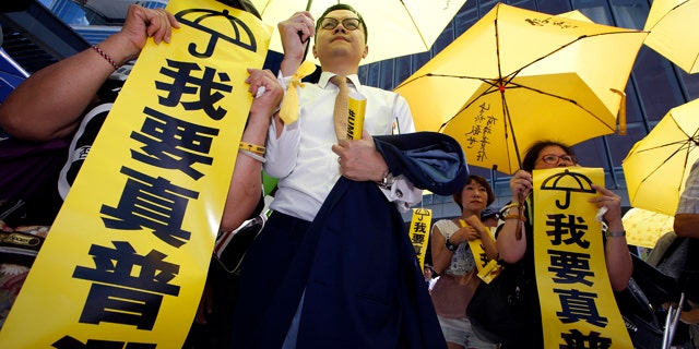 June 18, 2015: Pro-democracy protesters display placards reading I want genuine universal suffrage outside the Legislative Council in Hong Kong. The Hong Kong government's controversial Beijing-backed election reforms were defeated Thursday by pro-democracy lawmakers. (AP Photo/Kin Cheung)
