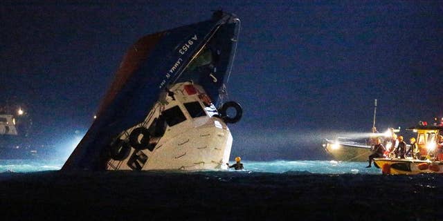 FILE - In this Oct. 2, 2012 file photo, rescuers check on a half submerged boat after it collided near Lamma Island, off the southwestern coast of Hong Kong. The captain of the Hong Kong commuter ferry that collided with another boat, killing 39 people, was found guilty of manslaughter on Saturday, Feb. 14, 2015 local media reported. A nine-member jury also found Lai Sai-ming guilty of endangering the safety of others at sea, in what was Hong Kong's biggest maritime tragedy in decades, the South China Morning Post newspaper and Radio Television Hong Kong said. (AP Photo/Kin Cheung, File)