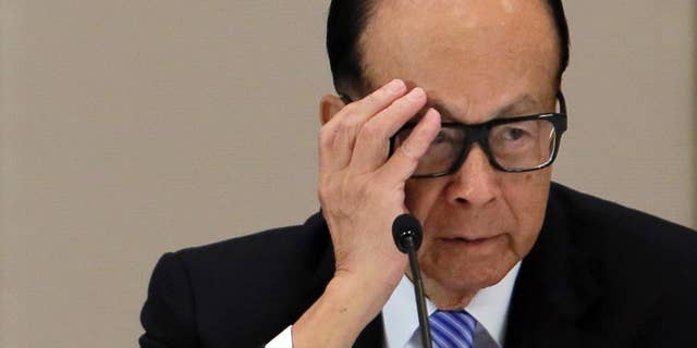 FILE - In this Jan. 9, 2015 file photo, Hong Kong tycoon Li Ka-shing reacts during a press conference in Hong Kong. Hong Kong billionaire Li has defended his business strategy against criticism in China's state media that accused him of abandoning the country because of its slowing growth.(AP Photo/Vincent Yu)