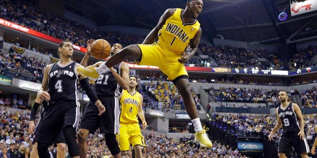 FILE - In this March 31, 2014, file photo, Indiana Pacers guard Lance Stephenson (1) reacts after a slam dunk over San Antonio Spurs guard Danny Green (4) and forward Tim Duncan (21) during the first half of an NBA basketball game in Indianapolis. A person familiar with the contract says free-agent shooting guard Lance Stephenson has agreed to a $27 million, three-year deal with the Charlotte Hornets. The deal includes a team option for the third season. (AP Photo/Michael Conroy, File)