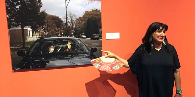 This Wednesday, July 27, 2016 photo acclaimed Mexican-American author Sandra Cisneros points to a photograph by Cecil McDonald, Jr., at the National Hispanic Cultural Center in Albuquerque, N.M. at an exhibit based by her 1984 novel "The House of Mango Street." The exhibit "The House on Mango Street: Artists Interpret Community" features major themes of the novel of a Mexican-American girl coming of age in Chicago. (AP Photo/Russell Contreras)