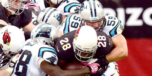 GLENDALE, AZ - OCTOBER 06: Rashard Mendenhall #28 of the Arizona Cardinals runs with the ball while dragging Thomas Davis #58 and Luke Kuechly #59 of the Carolina Panthers down the field at University of Phoenix Stadium on October 6, 2013 in Glendale, Arizona. Arizona won 22-6. (Photo by Norm Hall/Getty Images)