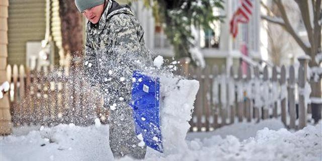 Spc. Cory Amato, from Fort Drumm, shovels snow from the sidewalk outside his house on Franklin Street Wednesday, Nov. 19, 2014, in Watertown, N.Y.