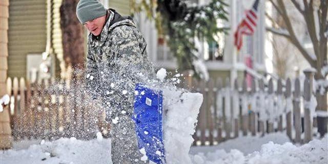Spc. Cory Amato, from Fort Drumm, shovels snow from the sidewalk outside his house on Franklin Street Wednesday, Nov. 19, 2014, in Watertown, N.Y.