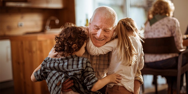 A grandfather huggs his young grandkids. Dr. Meg Meeker explains, "Many parents (or grandparents) fall into the trap of overspeaking, of giving too much information that kids can't handle or understand" when it comes to situations such as war or tragedies, she notes.