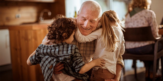 A grandfather huggs his young grandkids. Dr. Meg Meeker explains, "Many parents (or grandparents) fall into the trap of overspeaking, of giving too much information that kids can't handle or understand" when it comes to situations such as war or tragedies, she notes.