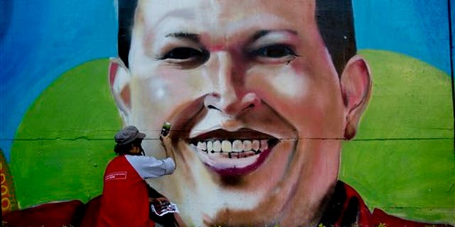 FILE.- In this Tuesday, Feb. 25, 2014 file photo, artist Nicolay Shamanika retouches a mural of Venezuela's former President Hugo Chavez in Caracas, Venezuela. Heartfelt devotion is a crucial but fading force for Chavezs hand-picked successor, President Nicolas Maduro. Despite daily invocations of his mentor, and control of the powerful party apparatus he inherited, Maduro is increasingly on his own in a fight against a destabilizing wave of anti-government protests.(AP Photo/Rodrigo Abd, File)