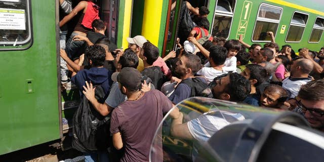 Migrants get back on a train in Bicske, Hungary, Thursday, Sept. 3, 2015. Over 150,000 migrants have reached Hungary this year, most coming through the southern border with Serbia. Many apply for asylum but quickly try to leave for richer EU countries. (AP Photo/Petr David Josek)