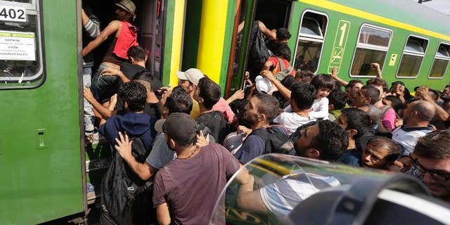 Migrants get back on a train in Bicske, Hungary, Thursday, Sept. 3, 2015. Over 150,000 migrants have reached Hungary this year, most coming through the southern border with Serbia. Many apply for asylum but quickly try to leave for richer EU countries. (AP Photo/Petr David Josek)