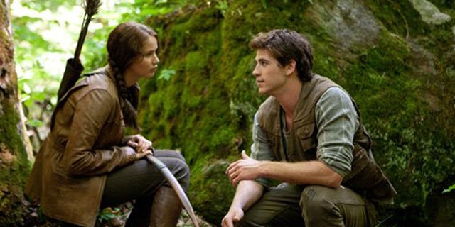 In this image released by Lionsgate, Jennifer Lawrence portrays Katniss Everdeen, left, and Liam Hemsworth portrays Gale Hawthorne in a scene from 'The Hunger Games.'
