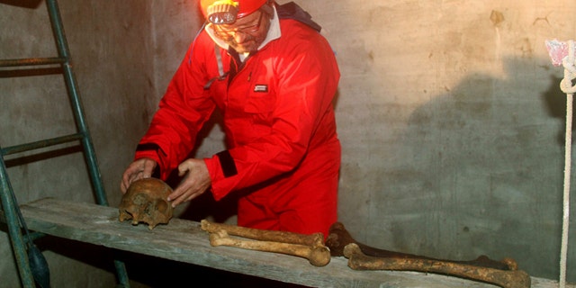 Italian researcher Antonio Moretti collects bones on a wooden board inside the crypt of San Sebastiano cemetery, in Porto Ercole, Italy. Moretti and a team of fellow scientists and academics want to solve the mystery surrounding the death of one of Italy's greatest artists: Caravaggio.