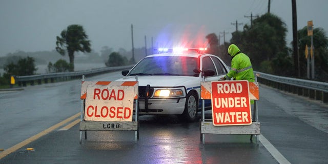 Police block the road entering Cedar Key, Fla., as Hurricane Hermine nears the Florida coast, Thursday, Sept. 1, 2016.