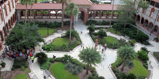 In this photo taken Oct. 28, 2016, people gather in the courtyard of Flagler College in St. Augustine, Fla. The building constructed in 1888, a registered national landmark, was flooded by 3-to-4-feet of storm surge during Hurricane Matthew. More than 1,000 students were evacuated prior to the storm, but the school managed to reopen a week after the storm passed. (AP Photo/Jason H. Dearen)