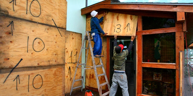 June 29: Norecio Salazar and Leonardo Salinas place a sheet of designated plywood over a window on Jim and JoAnne Farber's home on the Delta Lake Reservoir in preparation for Tropical Storm Alex. (AP)