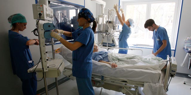 Nurses check a patient in the intensive care unit.
