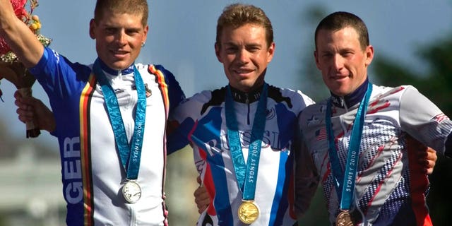 Sept. 30, 2000: In this file photo Russia's Viacheslav Ekimov, center, winner of the gold medal in the men's individual time trials, celebrates with Germany's silver medal winner Jan Ullrich, left, and U.S bronze medal winner Lance Armstrong at the cycling road course in Sydney, for the Summer Olympic Games.