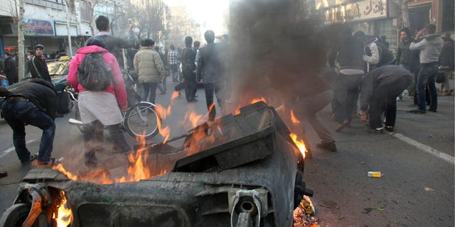 Feb. 14, 2011: This photo shows Iranian protestors attending an anti-government protest as a garbage can is set on fire, in Tehran, Iran.