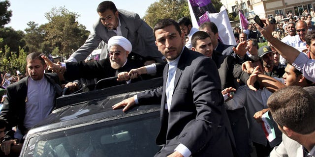 Sept. 28: Iranian President Hassan Rouhani, center, waves to supporters upon his arrival from the US near the Mehrabad airport in Tehran, Iran.
