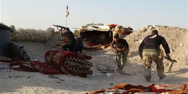 In this photo taken Monday, June 15, 2015, Iraqi security forces defend their positions against an Islamic State attack in Husaybah, 5 miles east of Ramadi, Iraq. (AP Photo)