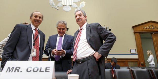 Deputy Attorney General James Cole, right, arrives on Capitol Hill in Washington, Thursday, July 17, 2014, to testify before the House Economic Growth, Job Creation, and Regulatory Affairs subcommittee hearing on how the Justice Department is investigating allegations that the Internal Revenue Service (IRS) targeted conservative political groups for extra scrutiny.