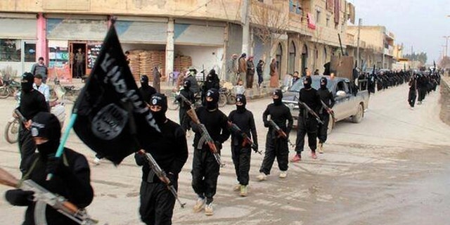 ISIS fighters march in the streets of their former caliphate' in Raqqa, Syria. 